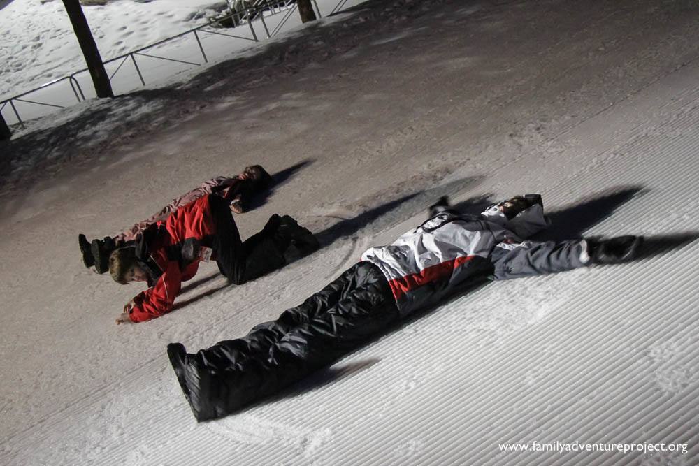 Kids making snow angels at night Kids making snow angels at night