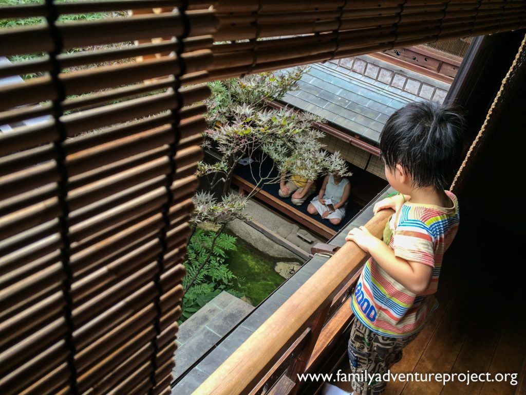 Child watches visitors meditate at the Shima Geisha House, Kanaz