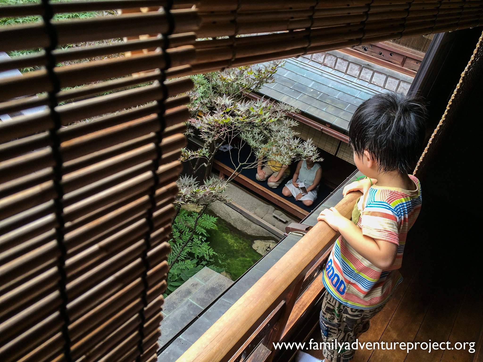 Child watches visitors meditate at the Shima Geisha House, Kanaz