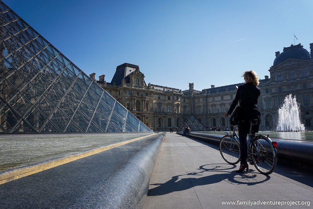Cyclist stops to admire The Louvre Paris