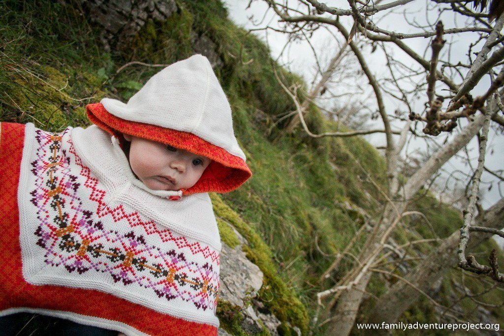 Baby in knitted poncho in Cumbria